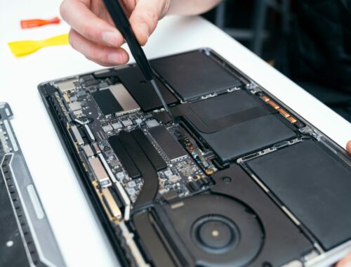 Unrecognizable Person Repairing Open Laptop's Internal Components